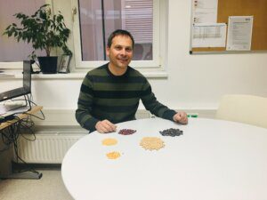 Alwera - Franz Wagners con campioni di fagioli, mais e altri prodotti al tavolo