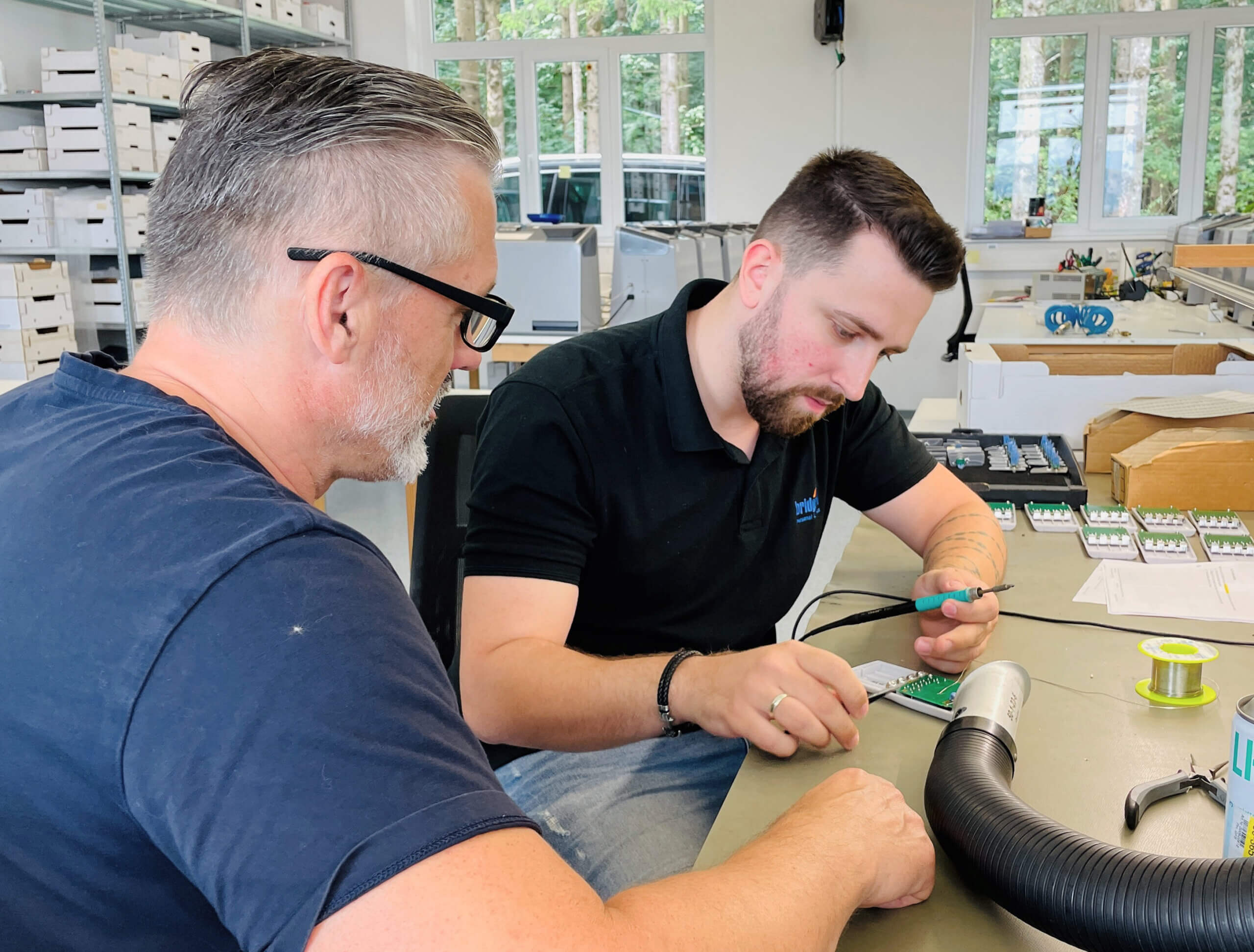 Richard und Marcel bei Lötübungen am Arbeitstisch