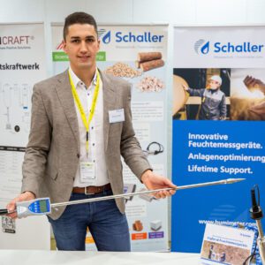Florian Postl mit einem humimeter BLL Messgerät für Hackschnitzel in der Hand. Am Messestand beim Heizwerke Betreibertag